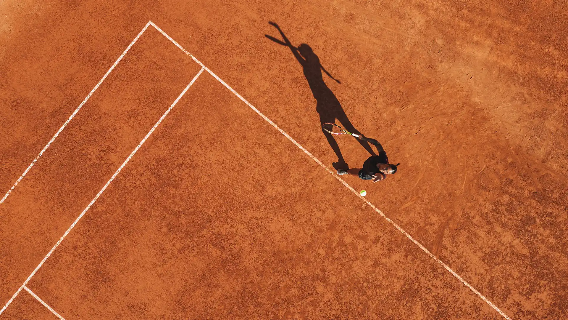 Aerial view of a tennis court with geometric lines
